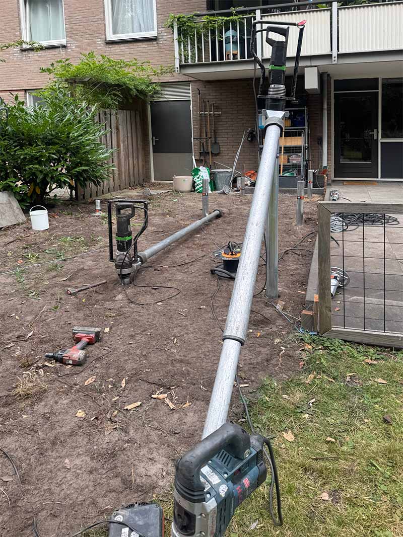 Handmachine voor schroeffunderingen in gebruik op moeilijk bereikbare locatie Amsterdam met compact boorgereedschap