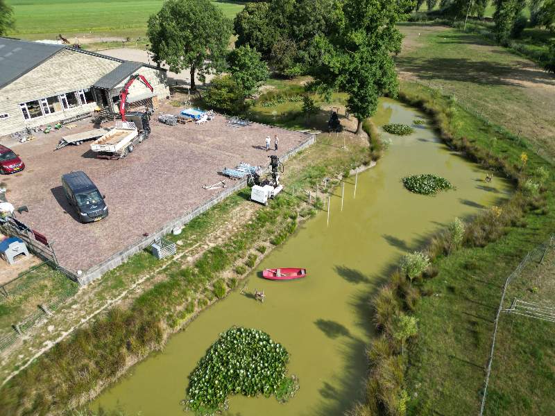 Van Aken monteert een schroeffundering deels in water in Kerkwijk