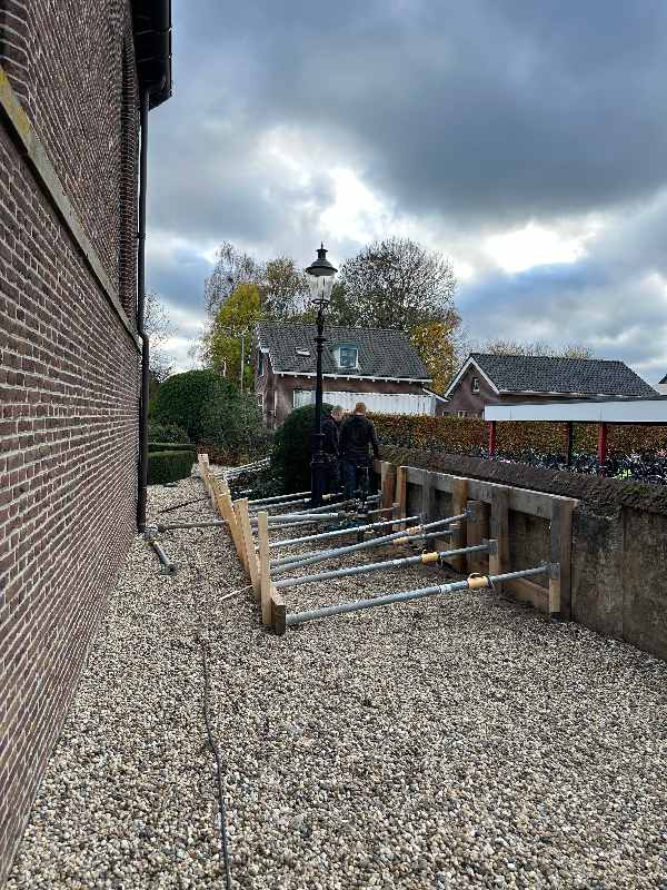 Fundering voor verstevigen kerkmuur door Van Aken