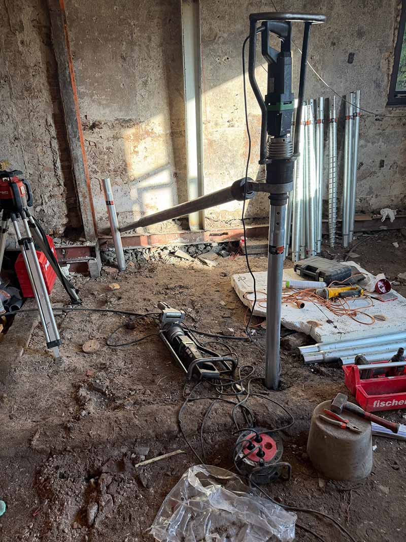 Schroefpaal V76 wordt met handmachine in veen- en kleigrond gedraaid in krap bijgebouw Rotterdam.