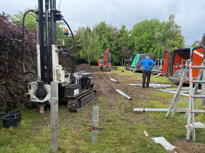 Van Aken Schroeffunderingen aan het werk met hydraulische machine en rupskraan bij buitenverblijf in Huissen