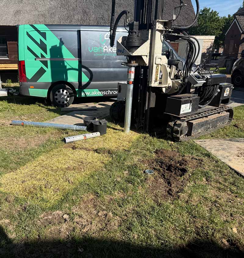 Hydraulische machine plaatst fundering voor zwembad in Huissen