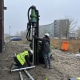 Monteurs van Van Aken plaatsen een schroefpaal van 9 meter voor de fundering van een prefab veranda bij een nieuwbouwproject in Badhoevedorp