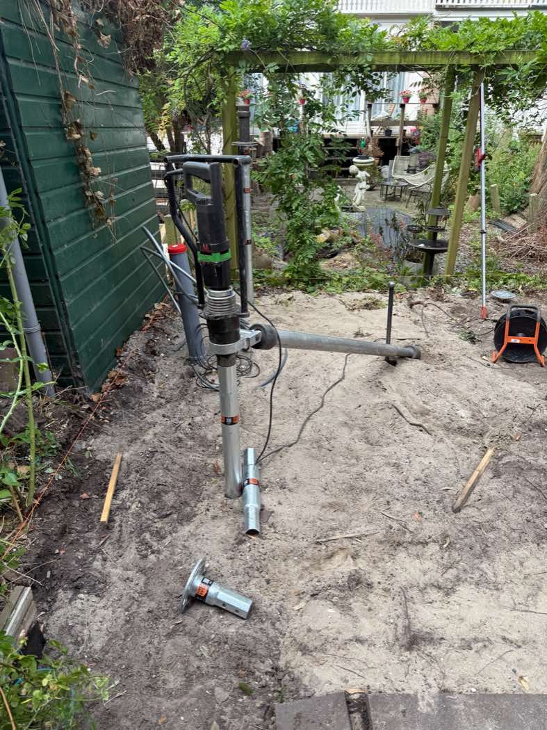 Handmachine met koppelbuis en verzinkte paalkop bij het indraaien van een schroefpaal van 76mm voor een kantoorunit in Amsterdam